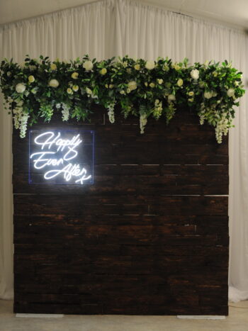 timber floral backdrop with neon sign