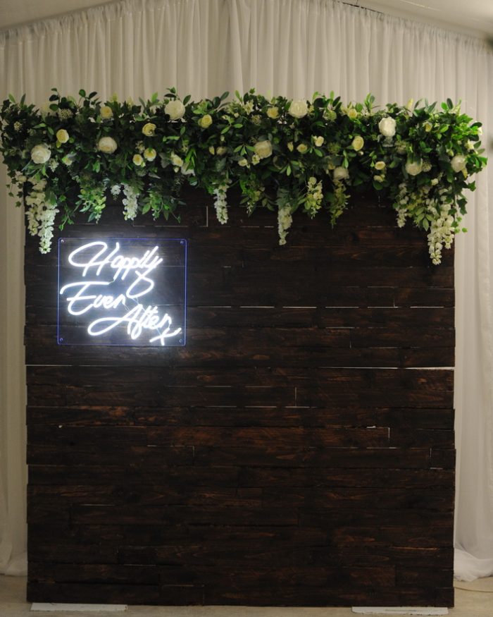 timber floral backdrop with neon sign